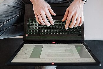 Zwei Hände auf der Laptoptastatur.